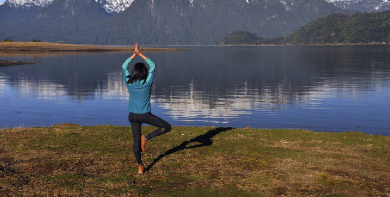 Yoga session by the Ganges River in Rishikesh with mountains in the backdrop