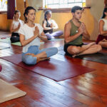 Modern yoga studio with students practicing under the guidance of an instructor, representing tips for choosing a yoga studio