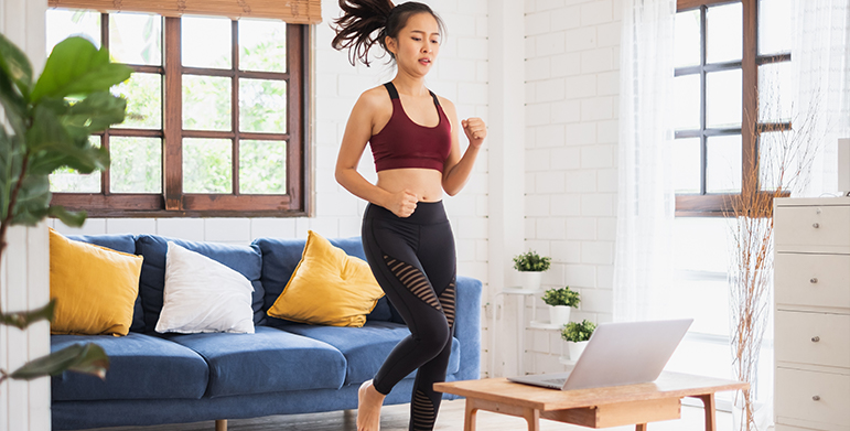 Woman following Zumba class online in living room
