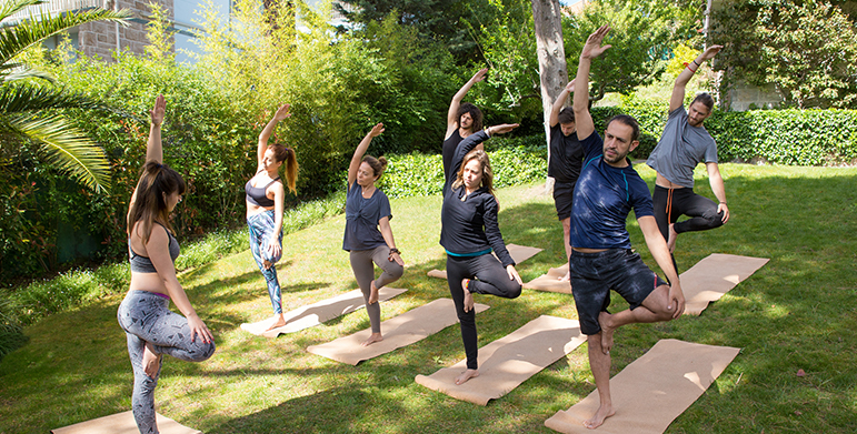Wellness travelers participating in yoga at an eco-friendly retreat in India
