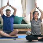 Certified yoga instructor guiding a student at home in Noida