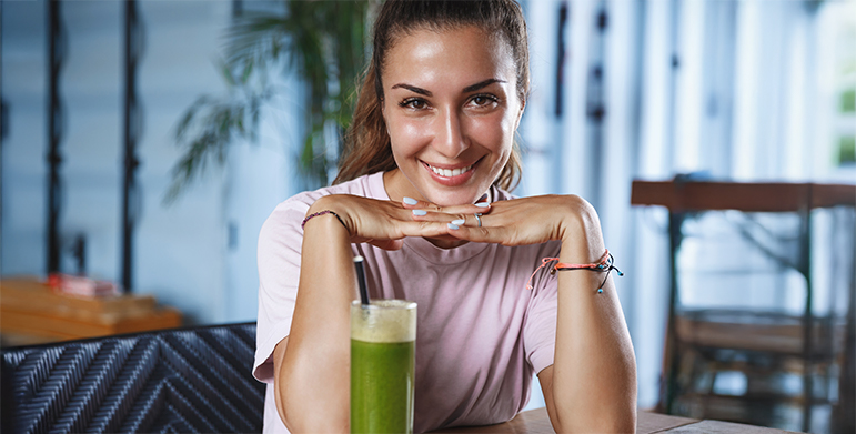 A glowing, relaxed guest at a retreat enjoying herbal tea or journaling near a window.